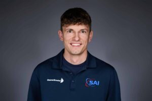 A smiling man with short brown hair wearing a navy blue polo shirt. The shirt has two logos: 'CleaverBrooks' on the left side and 'SAI' on the right side. The background is a neutral gray gradient.